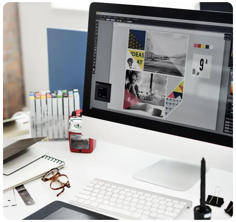 Designer's desk with a monitor showing a brand layout